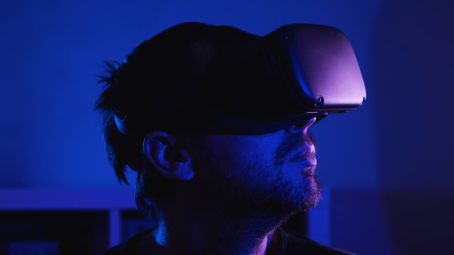 un homme barbu portant des lunettes VR dans une pièce sombre avec une lumière bleue par Vladimir Volovodov sur 500px.com